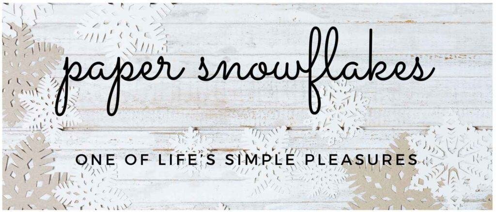 paper snowflake on a white washed background with the words "paper snowflakes - one of life's simple pleasures"